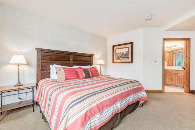 bedroom with light carpet and ensuite bath