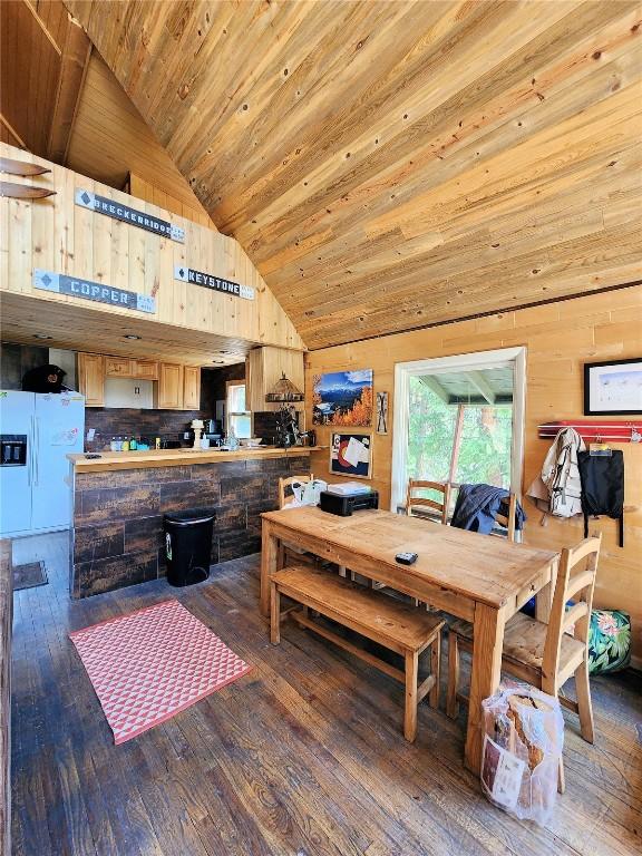 dining room featuring wood walls, high vaulted ceiling, wood ceiling, and hardwood / wood-style flooring