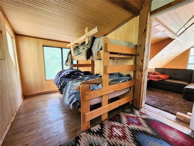 bedroom with wood walls, wood ceiling, and hardwood / wood-style flooring