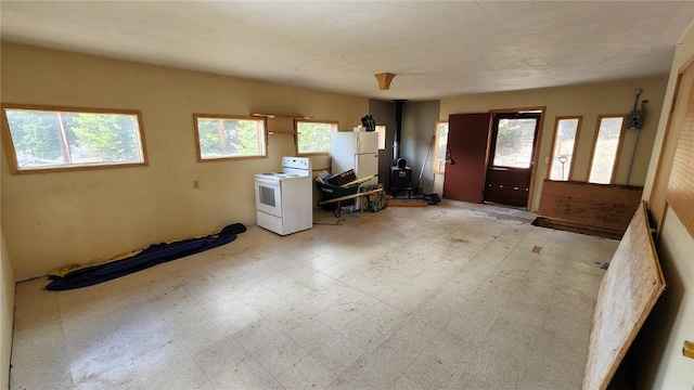 entryway with a wood stove and a healthy amount of sunlight