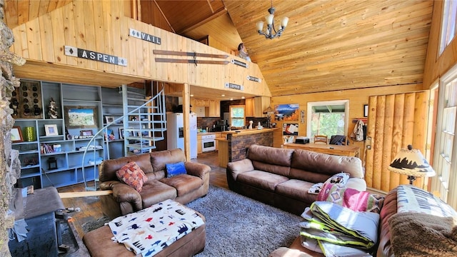 living room featuring a chandelier, wooden ceiling, high vaulted ceiling, and wooden walls