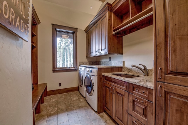 laundry area with a sink, baseboards, cabinet space, and washer and dryer