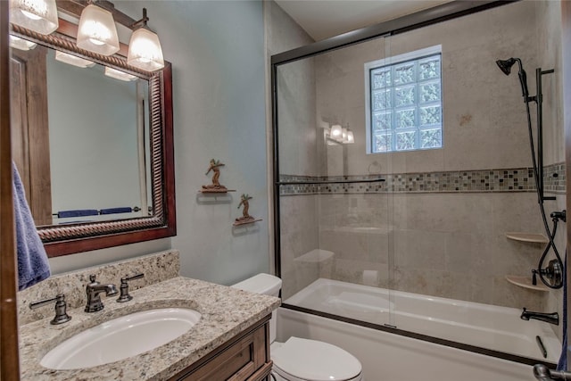 bathroom featuring vanity, toilet, and combined bath / shower with glass door