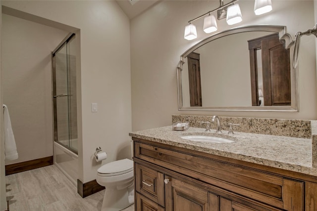 full bath with baseboards, bath / shower combo with glass door, toilet, wood finished floors, and vanity