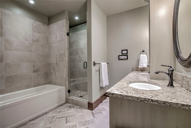 bathroom with a shower stall, double vanity, recessed lighting, a bath, and a sink