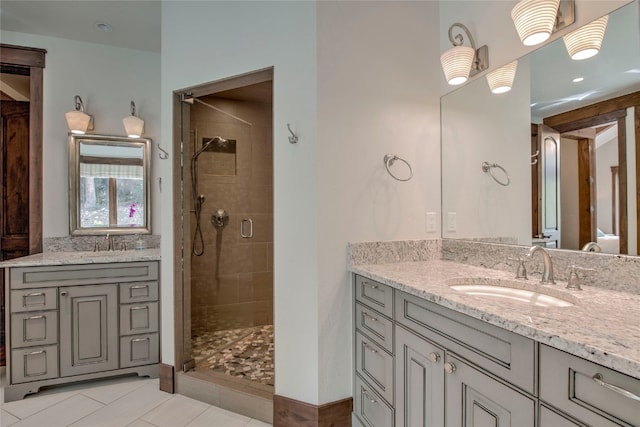 bathroom featuring a shower stall, two vanities, and a sink