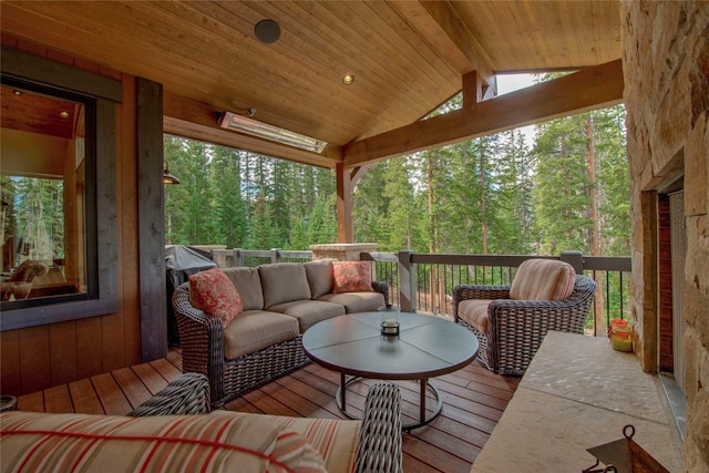 sunroom with wooden ceiling, a view of trees, and lofted ceiling