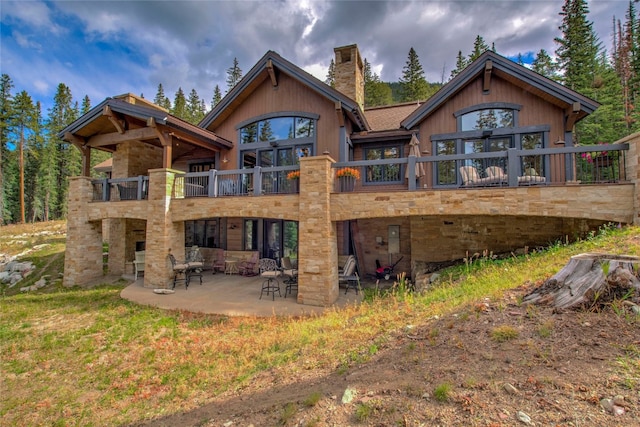 back of property with a patio area, a chimney, and a balcony