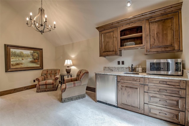 interior space with stainless steel microwave, light colored carpet, lofted ceiling, refrigerator, and a sink