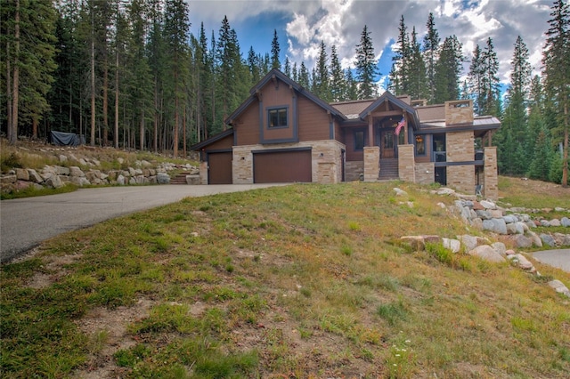 view of front of property with stone siding, driveway, and a garage