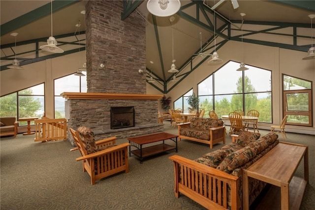 carpeted living room featuring a fireplace, a healthy amount of sunlight, beam ceiling, and high vaulted ceiling