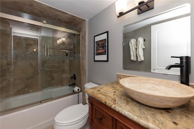 full bathroom featuring enclosed tub / shower combo, vanity, and toilet