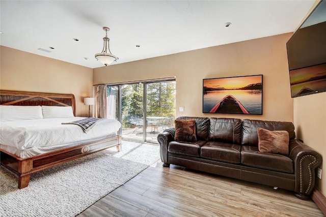 bedroom with access to exterior and light hardwood / wood-style flooring