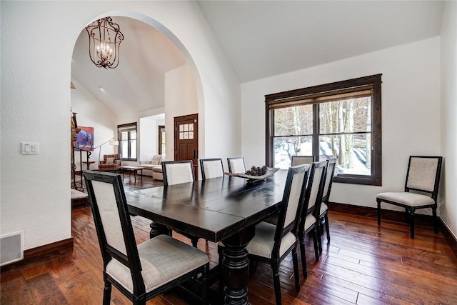 dining space featuring vaulted ceiling, a chandelier, and dark hardwood / wood-style floors