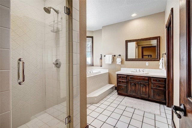 bathroom with tile patterned floors, vanity, and shower with separate bathtub