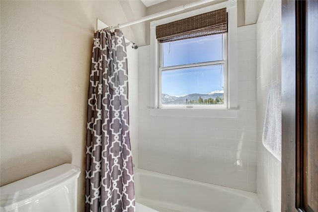 bathroom featuring toilet and shower / bath combo with shower curtain