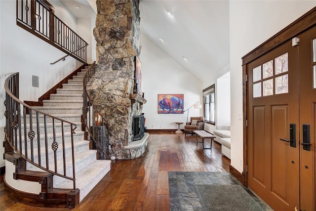 entryway featuring a fireplace, dark hardwood / wood-style flooring, and a high ceiling