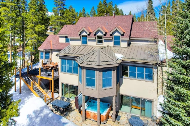 rear view of property with a hot tub