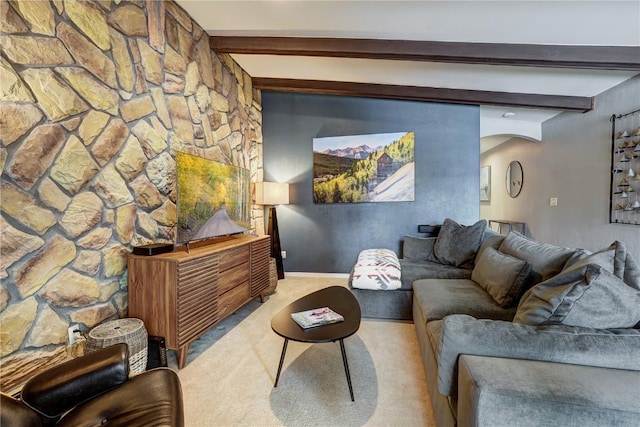 living room with beamed ceiling and light carpet