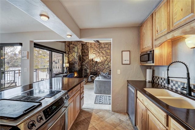 kitchen with light tile patterned flooring, stainless steel appliances, light brown cabinetry, and sink