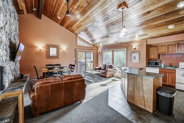 living room featuring a fireplace, high vaulted ceiling, decorative light fixtures, dark tile patterned flooring, and wooden ceiling