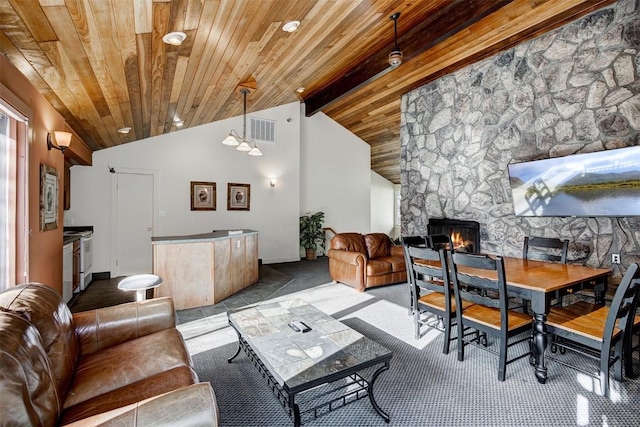 carpeted living room featuring wood ceiling, a fireplace, and vaulted ceiling with beams