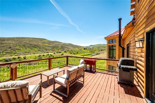 wooden deck featuring a mountain view, an outdoor hangout area, and area for grilling