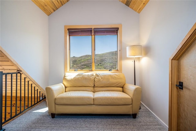 sitting room with a mountain view, wood ceiling, carpet floors, and lofted ceiling