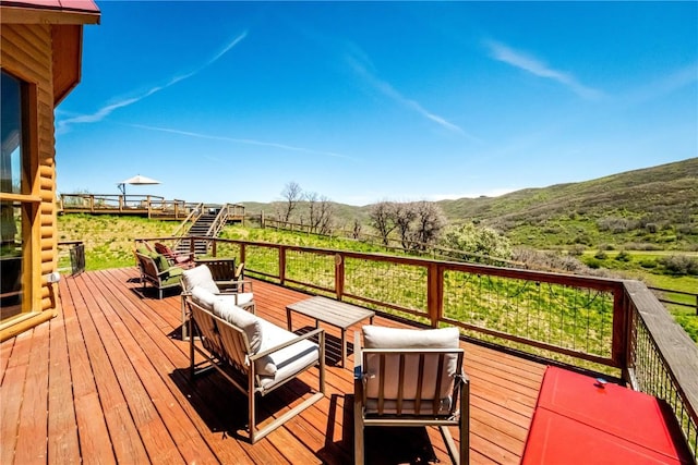 wooden deck with an outdoor living space and a mountain view