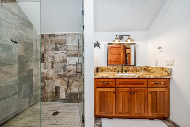 bathroom with vanity, tile patterned floors, a shower with shower door, and lofted ceiling