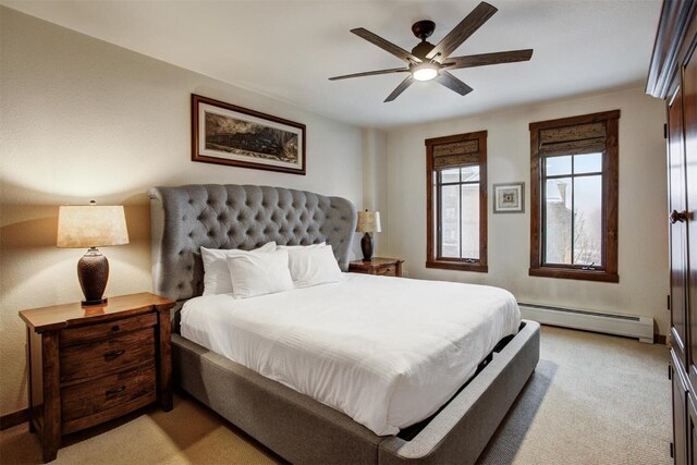 bedroom with a baseboard heating unit, ceiling fan, and light carpet