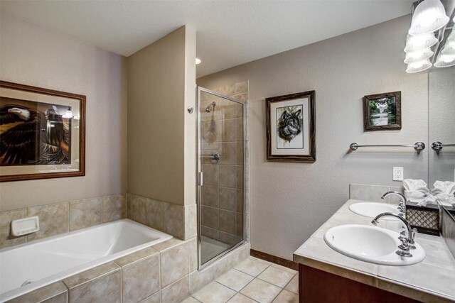 bathroom featuring tile patterned flooring, a sink, a shower stall, and a bath