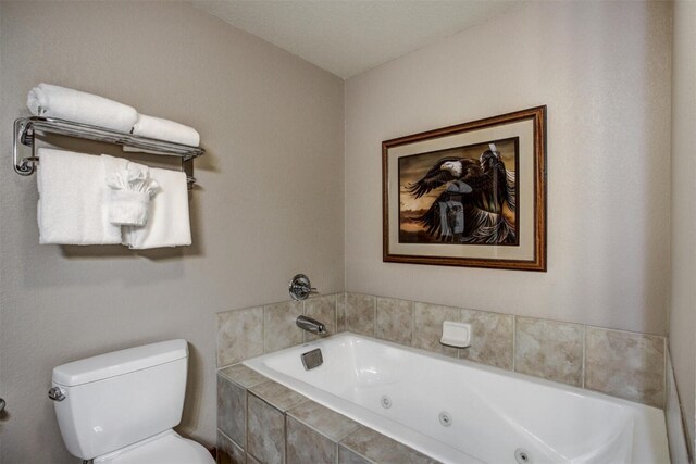 bathroom with a tub with jets and toilet