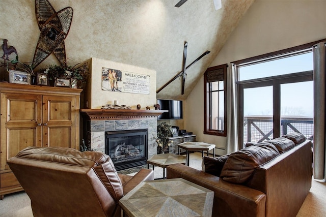 living room with light carpet, high vaulted ceiling, a tiled fireplace, and a ceiling fan