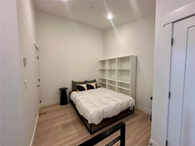 bedroom with light hardwood / wood-style floors and a closet