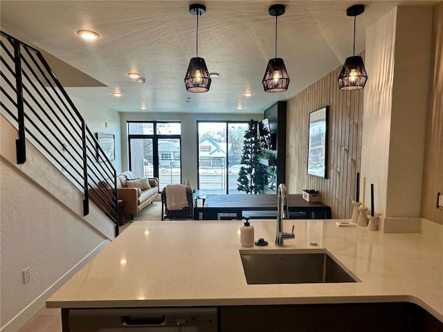 kitchen featuring dishwasher, sink, and hanging light fixtures