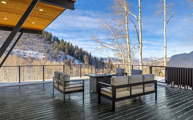 wooden terrace with a mountain view and an outdoor living space with a fire pit