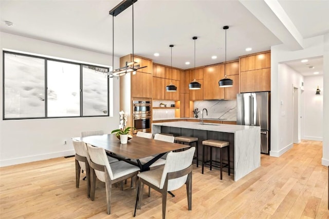 dining area with light wood-style floors, baseboards, and recessed lighting