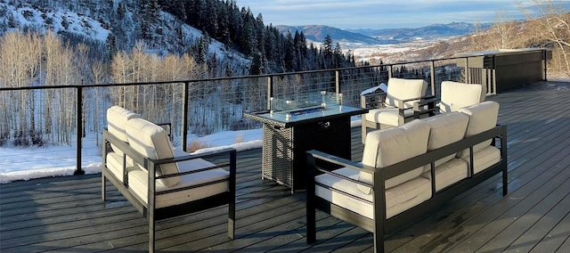 snow covered deck with outdoor lounge area and a mountain view