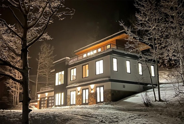 view of front of home with a balcony and stone siding