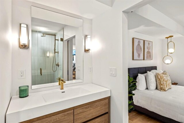 bathroom featuring wood finished floors, a shower stall, vanity, and connected bathroom