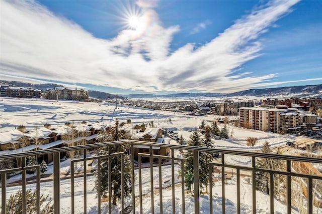 snow covered back of property with a mountain view