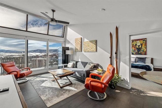 living room featuring a mountain view, ceiling fan, and vaulted ceiling