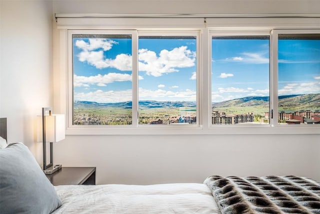 bedroom with a mountain view and multiple windows