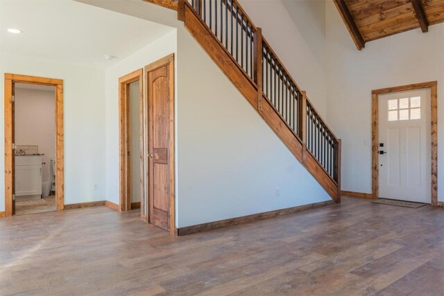 entrance foyer featuring hardwood / wood-style floors, lofted ceiling with beams, and wood ceiling