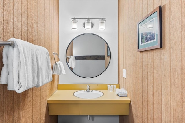 bathroom featuring vanity and wood walls