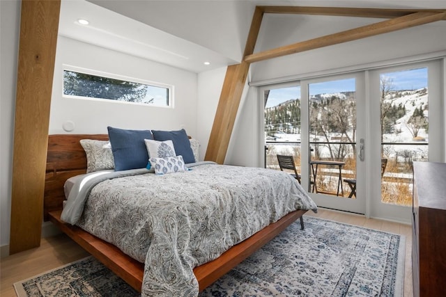 bedroom with access to exterior and hardwood / wood-style floors