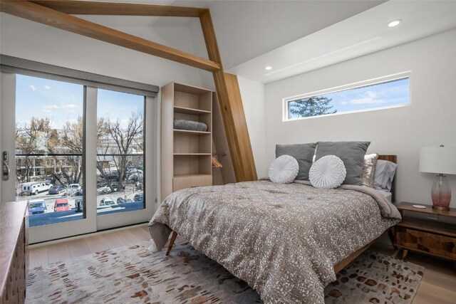 bedroom featuring access to exterior, light hardwood / wood-style flooring, and lofted ceiling