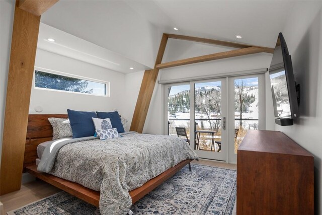 bedroom featuring access to outside, french doors, hardwood / wood-style floors, and vaulted ceiling