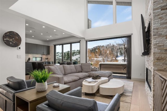 living room with light hardwood / wood-style flooring and a stone fireplace